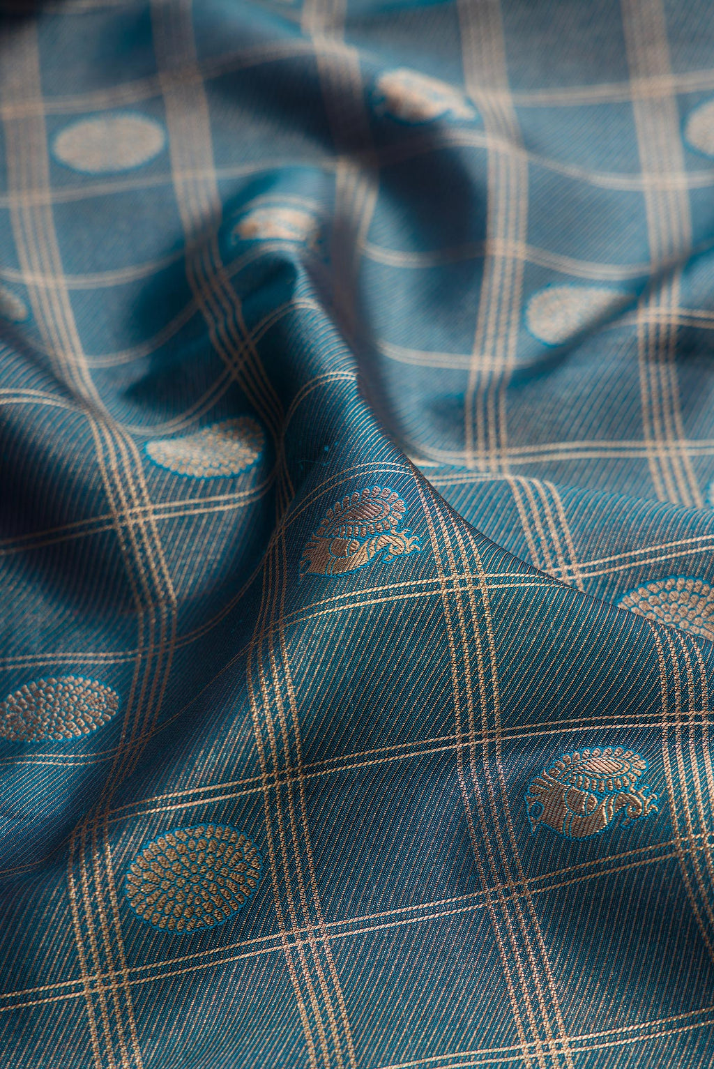 Close up of Pure Silk Teal Dual Tone Kanchipuram Saree with Zari Brocade on the body and Zari Border.  displaying folds
