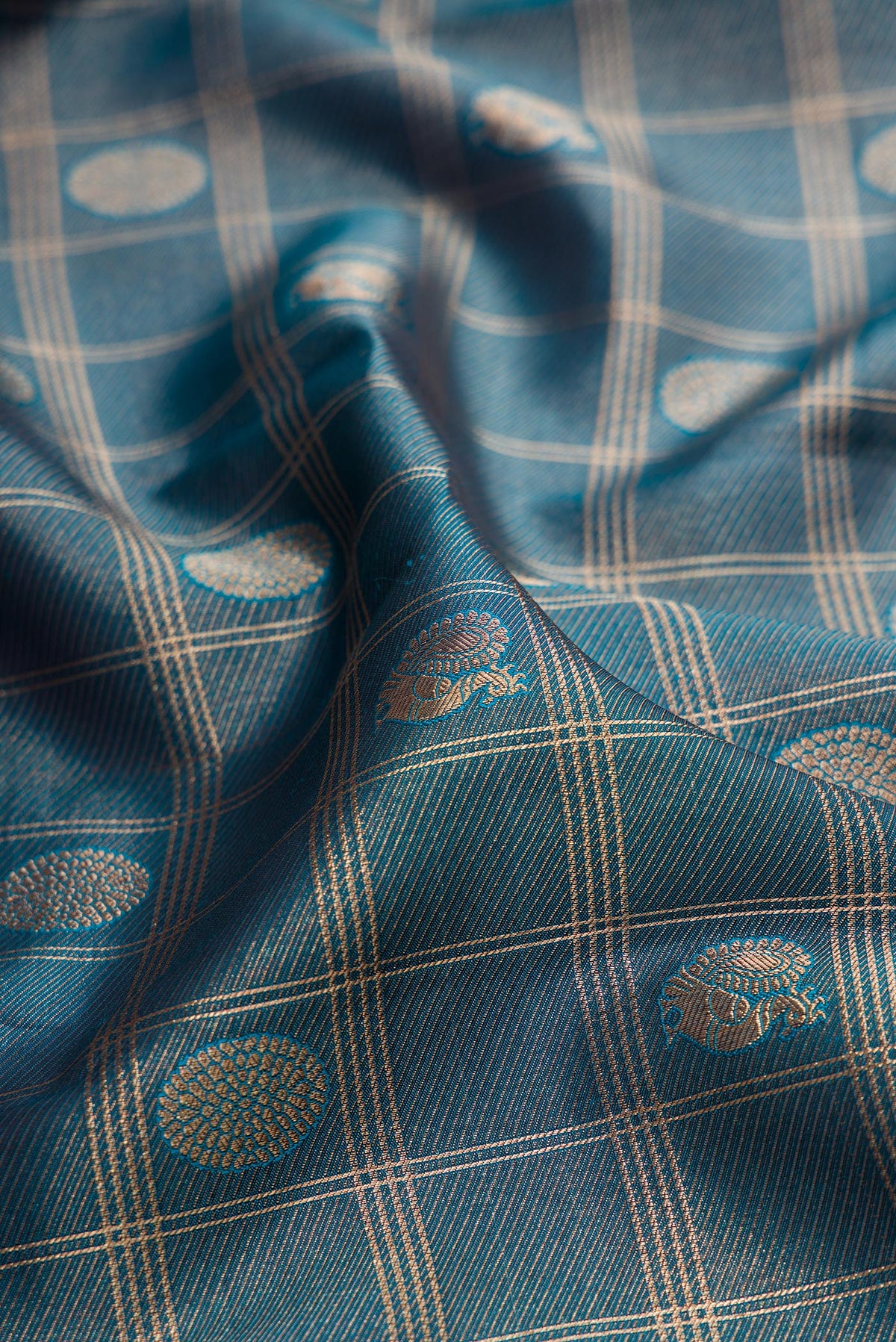 Close up of Pure Silk Teal Dual Tone Kanchipuram Saree with Zari Brocade on the body and Zari Border.  displaying folds