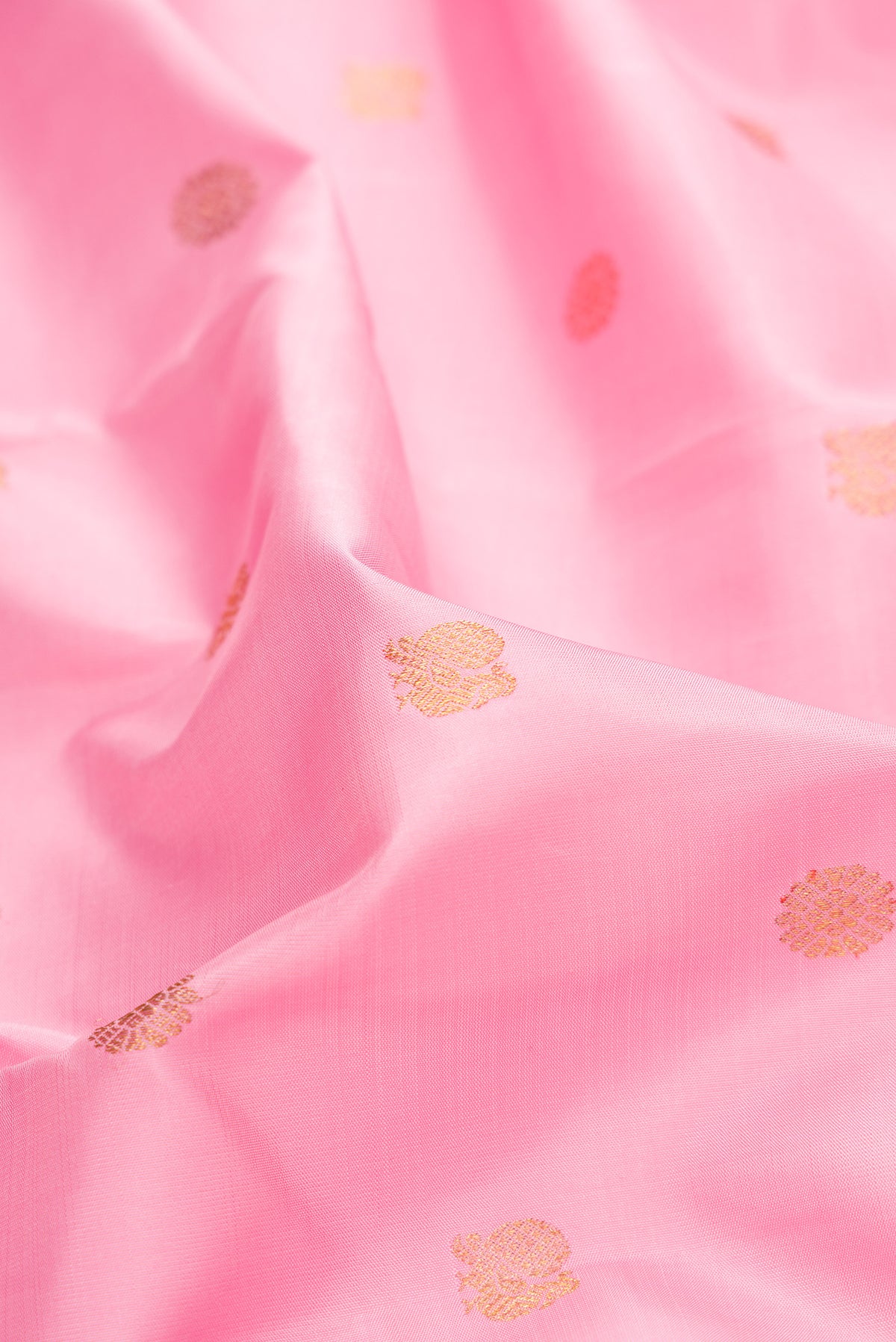 Close up of Pure Silk Pure Zari Pink Dual Tone Kanchipuram Saree with Zari Butta on the body and Zari Border.  displaying folds