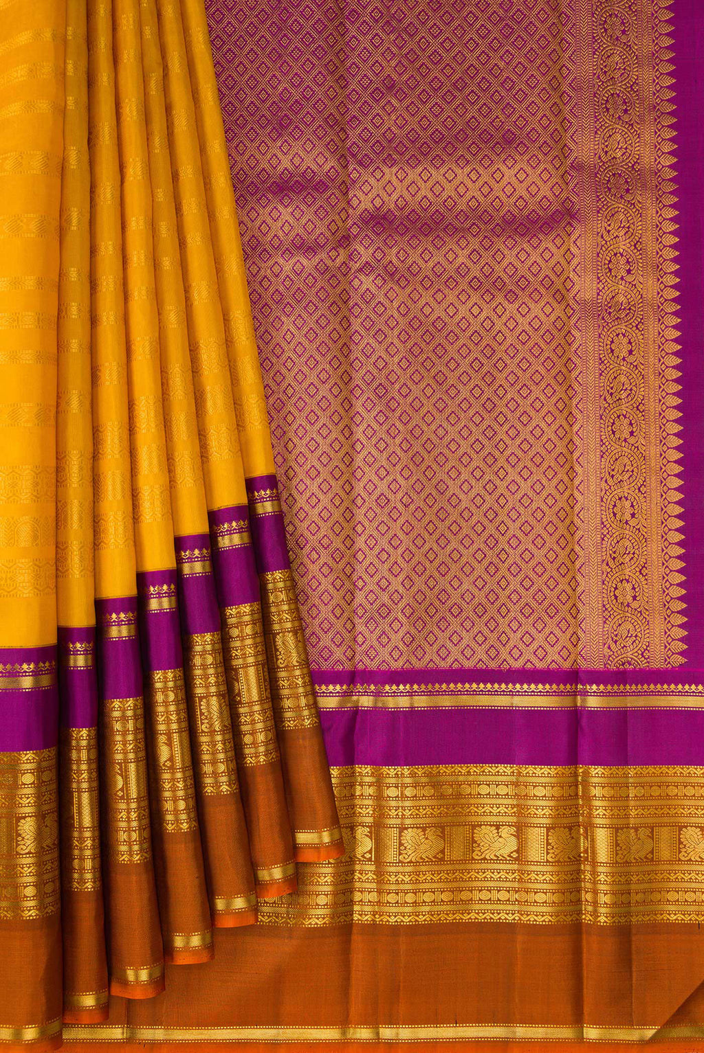 Pleats and pallu of Mustard Kanchipuram Silk Saree with Stripes on the body and Ganga Jamuna Border. 