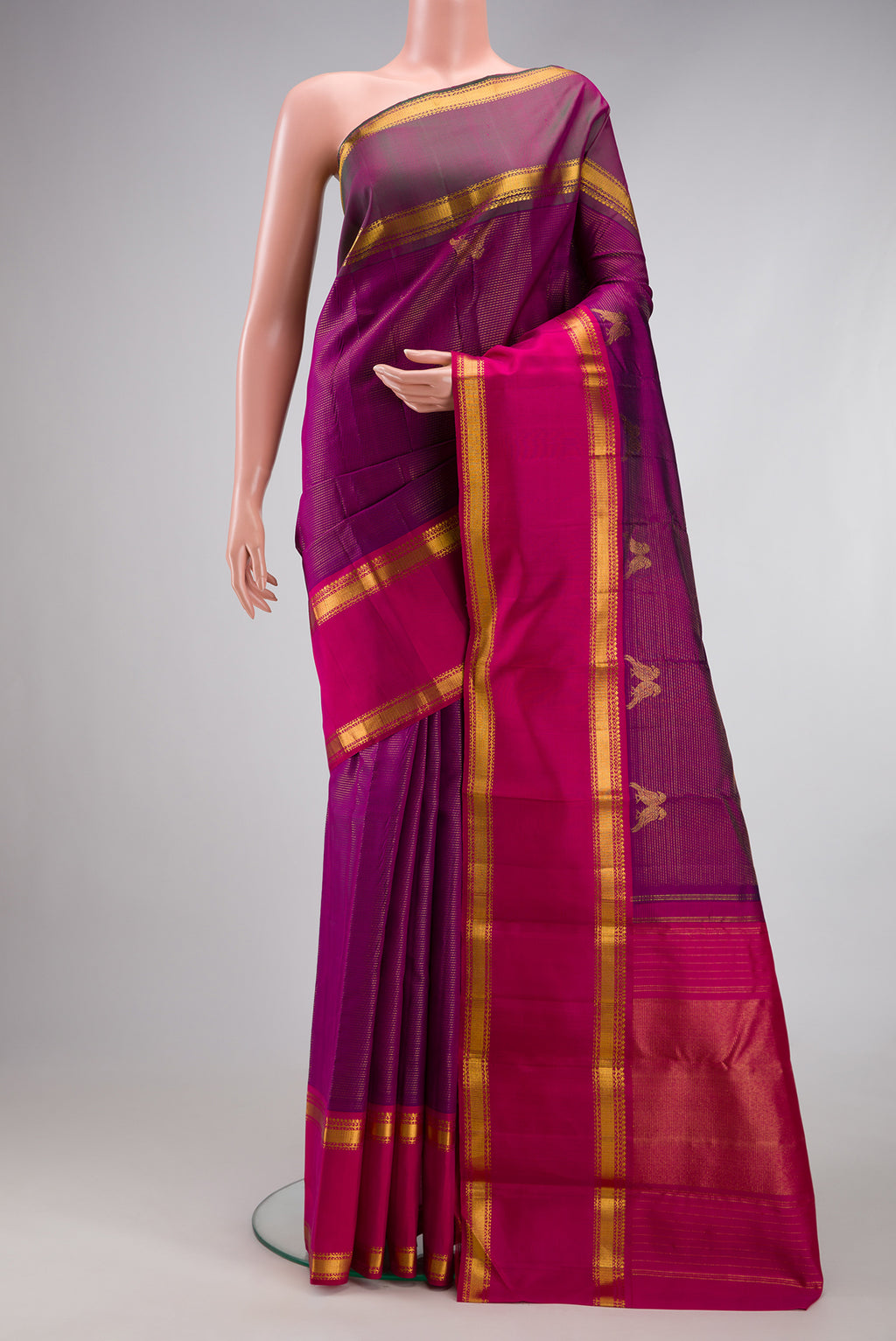 Magenta Kanjivaram Silk Saree with Stripes on the body and Ganga Jamuna Border.  displayed on a mannequin