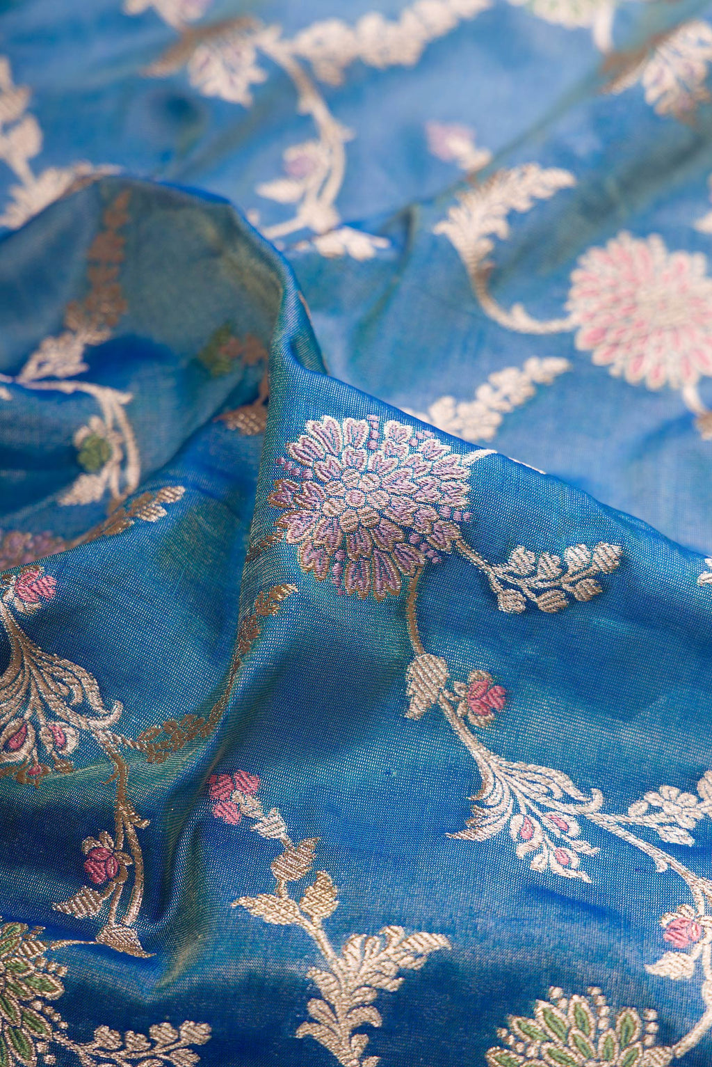 Close up of Peacock Blue Dual Tone Banarasi Silk Saree with Zari Brocade on the body and Fancy Border.  displaying folds