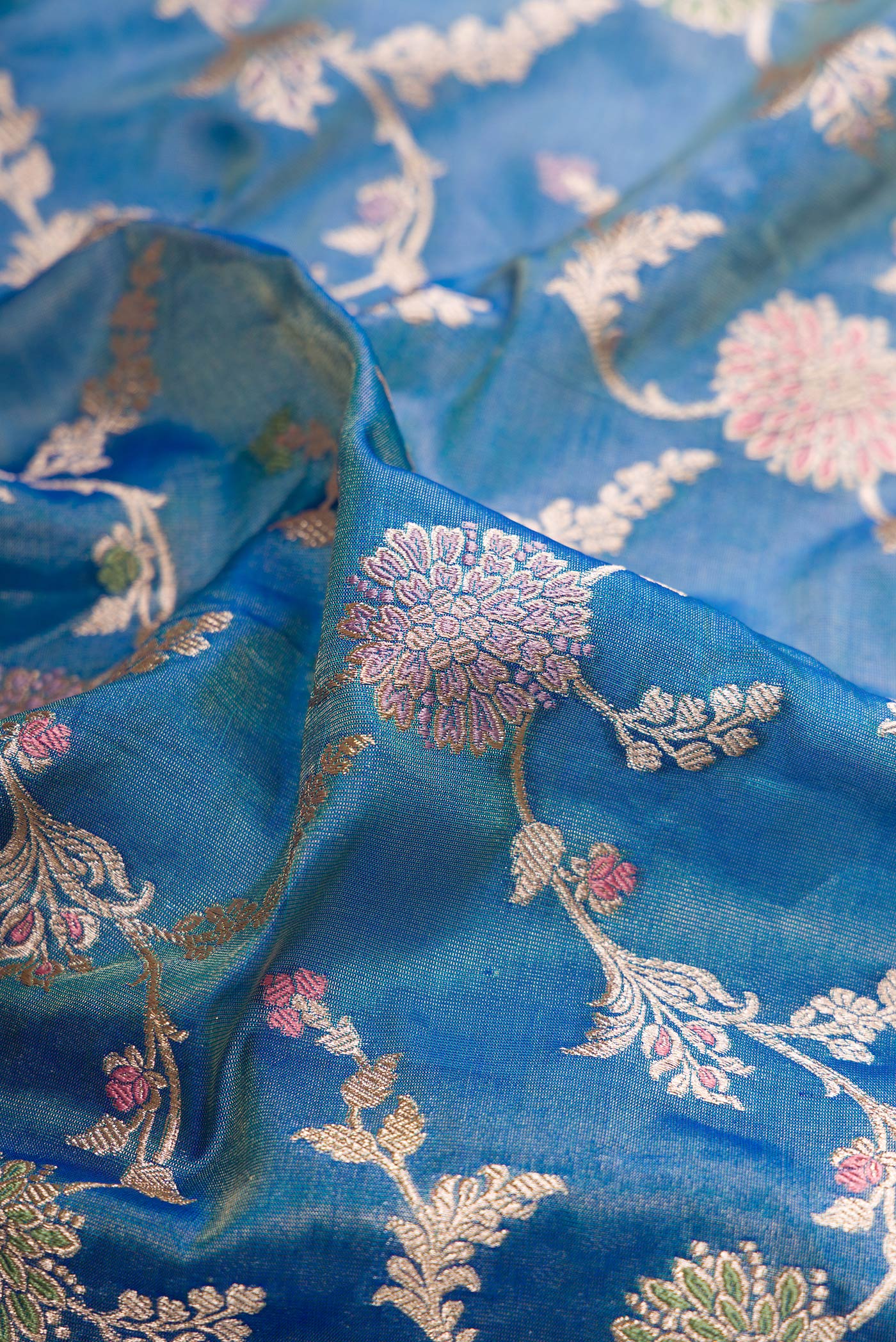 Close up of Peacock Blue Dual Tone Banarasi Silk Saree with Zari Brocade on the body and Fancy Border.  displaying folds