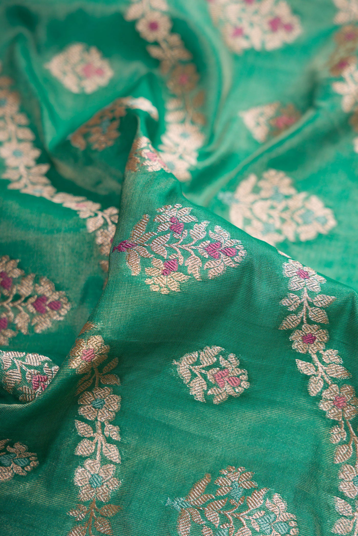 Close up of Green Dual Tone Banarasi Silk Saree with Zari Brocade on the body and Fancy Border.  displaying folds