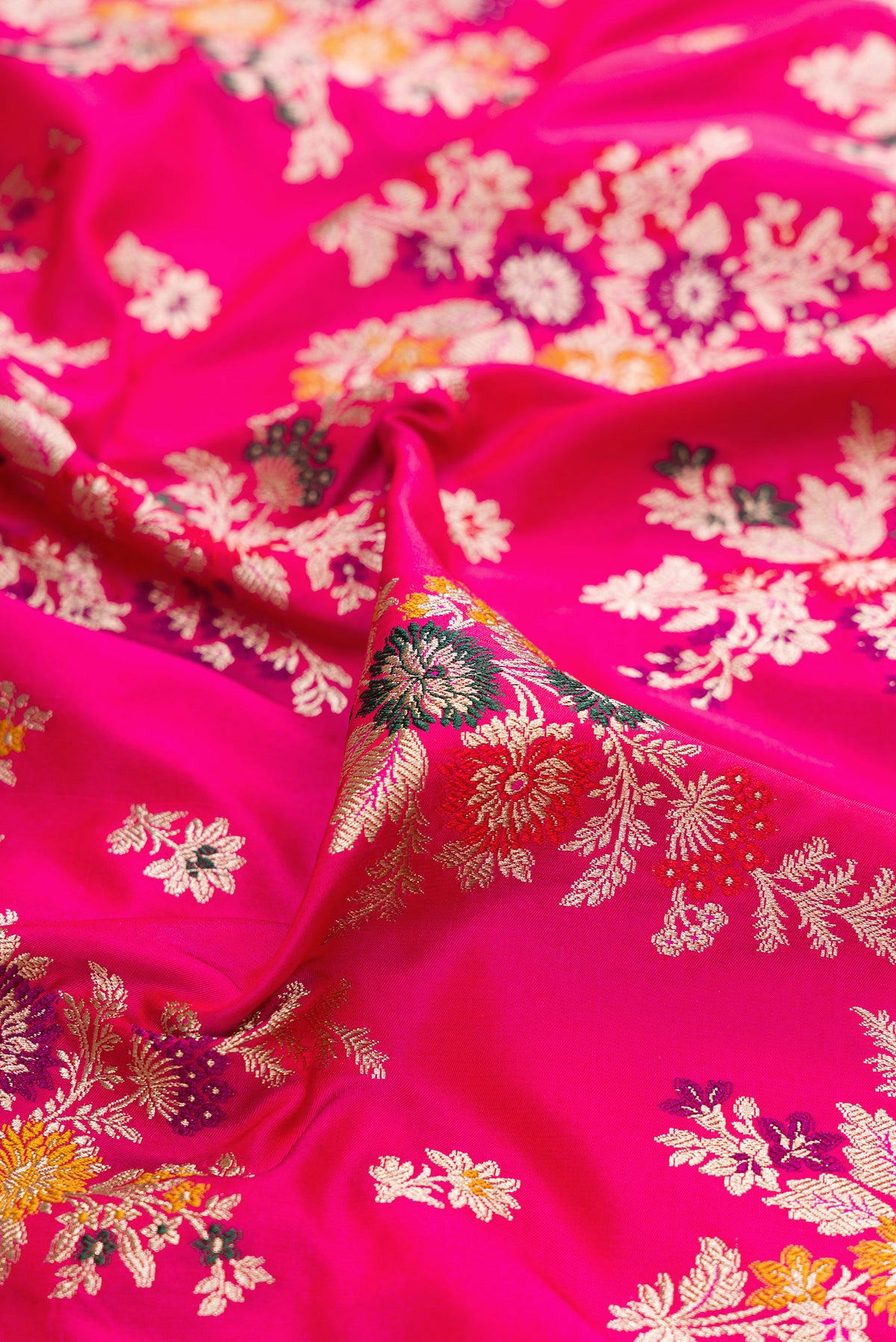 Close up of Dark Pink Banarasi Silk Saree with Zari Brocade on the body and Zari Border.  displaying folds