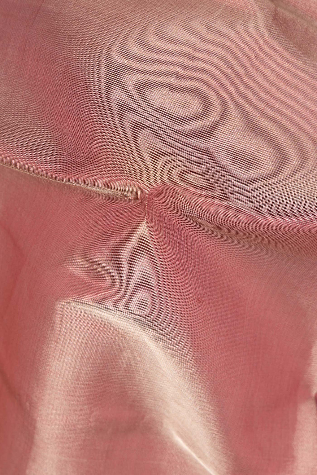 Close up of Rose Gold Dual Tone Organza Saree with Plain Body and Zari Border.  displaying folds