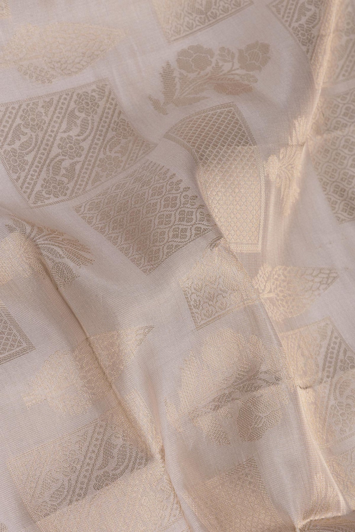 Close up of Pure Silk Beige Dual Tone Kanjivaram Saree with Zari Brocade on the body and Zari Border.  displaying folds