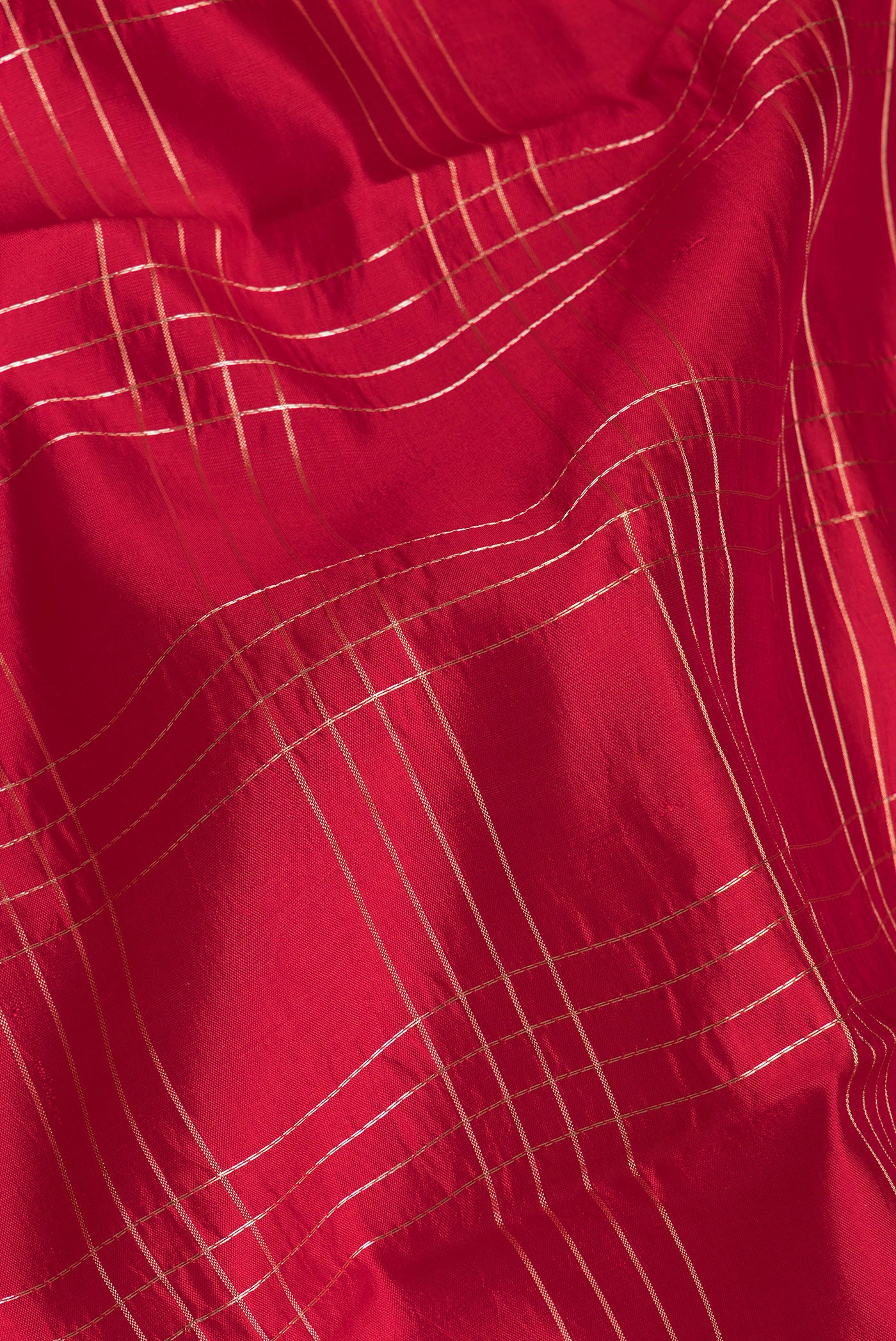 Close up of Red Tussar Silk Saree with Checked design on the body and Fancy Border.  displaying folds