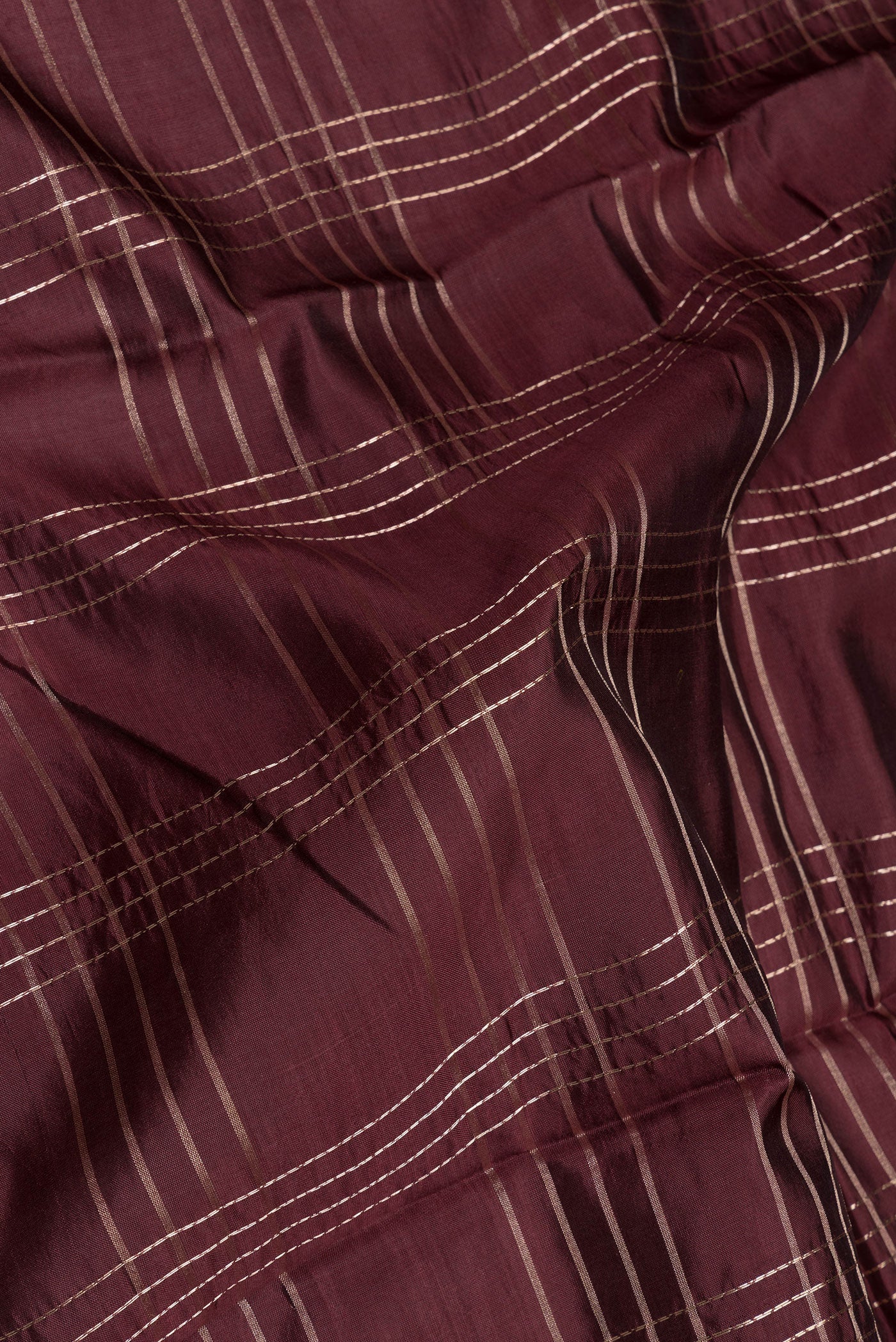 Close up of Coffee Brown Tussar Silk Saree with Checked design on the body and Fancy Border.  displaying folds