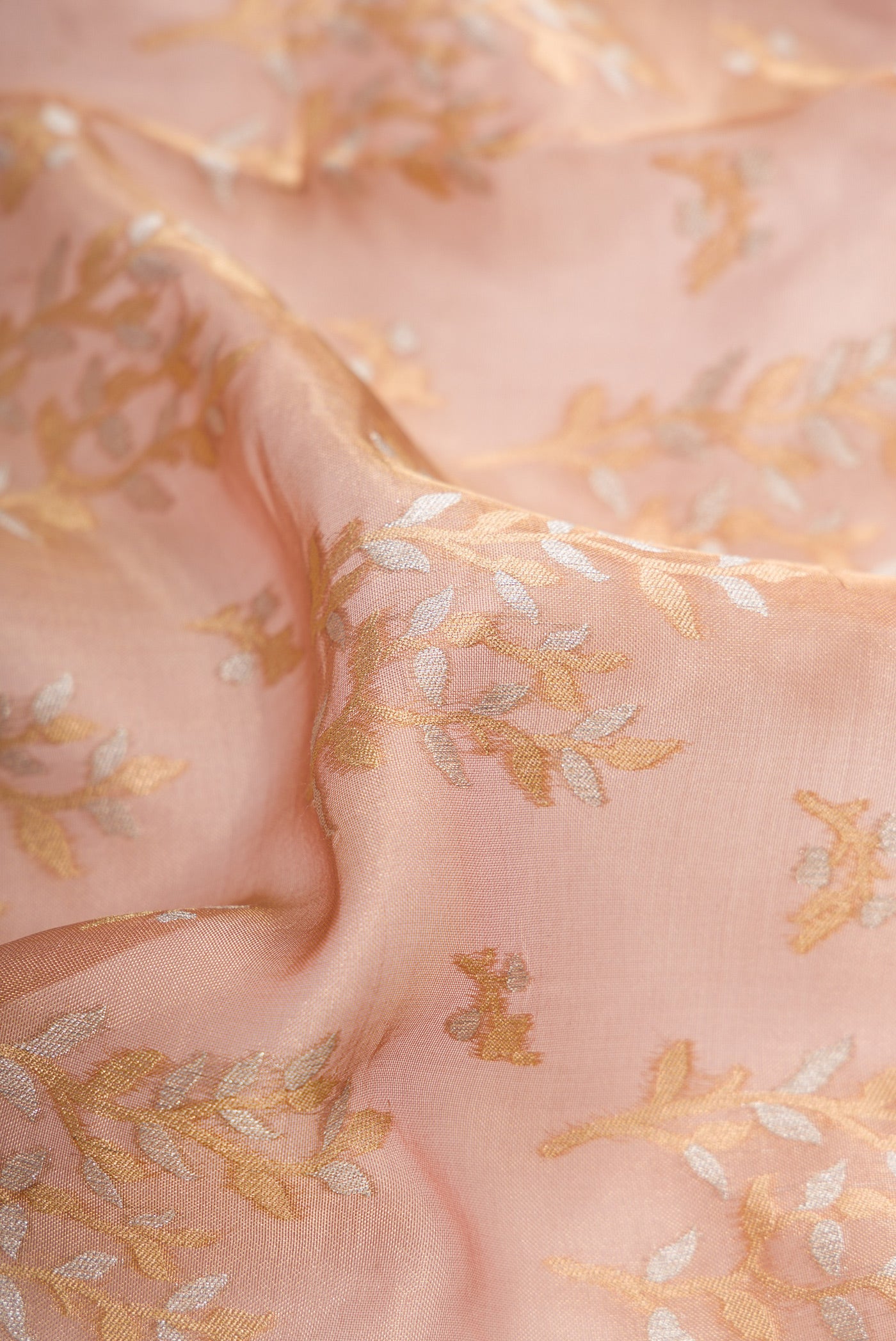 Close up of Rose Gold Dual Tone Banarasi Silk Saree with Zari Brocade on the body and Fancy Border.  displaying folds