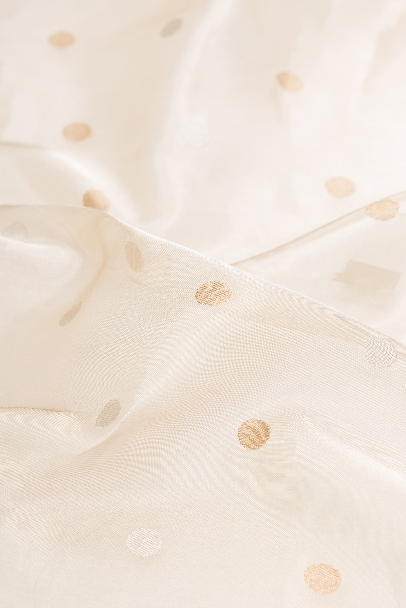 Close up of Cream Dual Tone Banarasi Silk Saree with Zari Brocade on the body and Zari Border.  displaying folds
