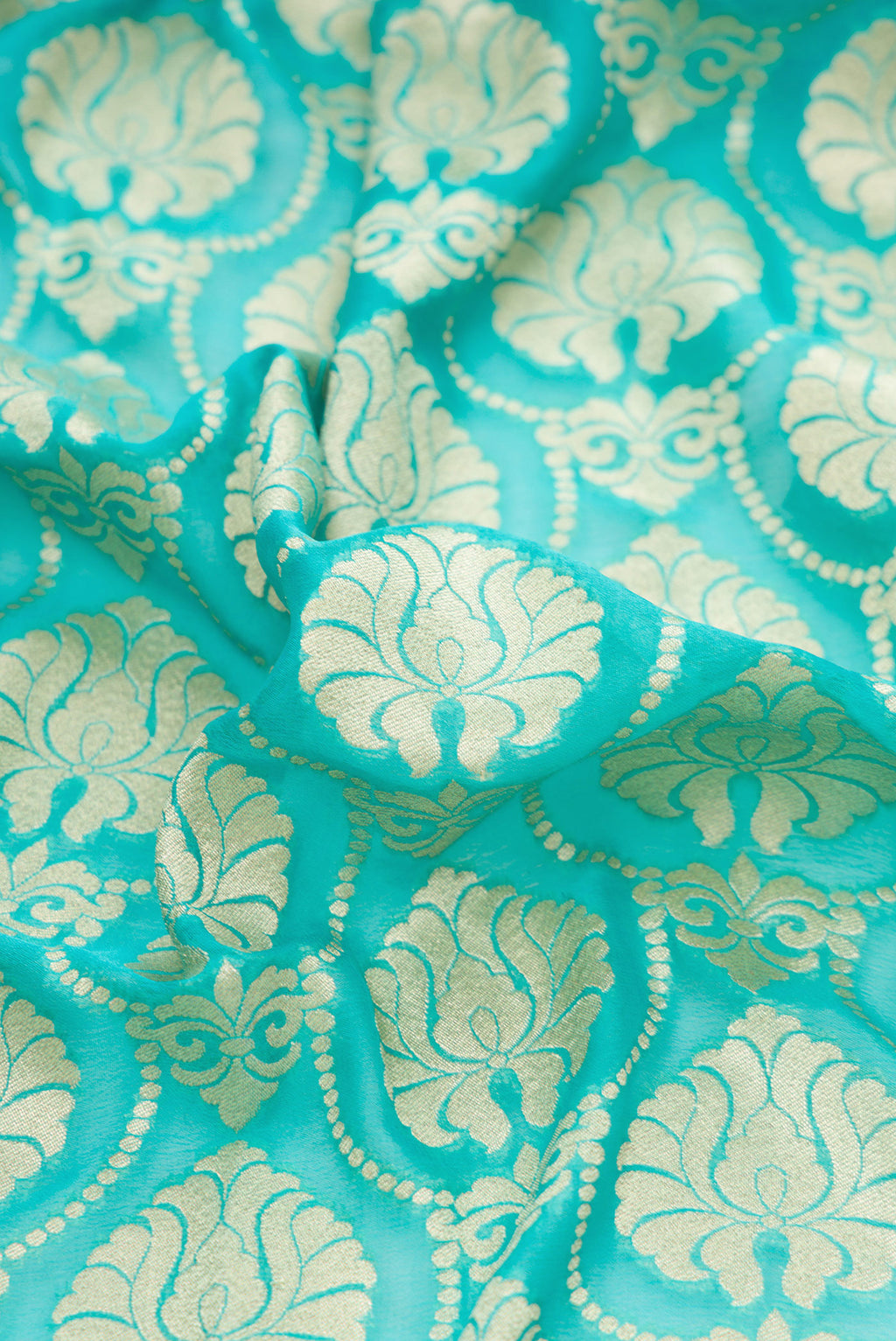 Close up of Sky Blue Banarasi Georgette Saree with Zari Brocade on the body and Fancy Border.  displaying folds