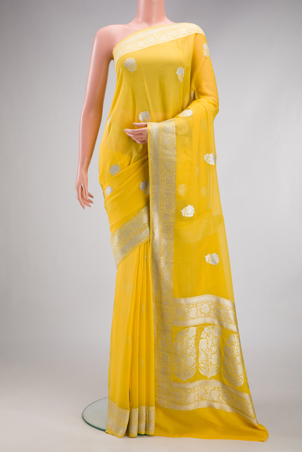 Yellow Banarasi Georgette Saree with Zari Butta on the body and Zari Border.  displayed on a mannequin