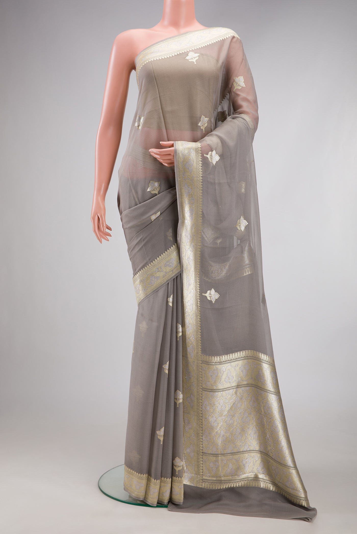 Grey Banarasi Georgette Saree with Zari Butta on the body and Zari Border.  displayed on a mannequin
