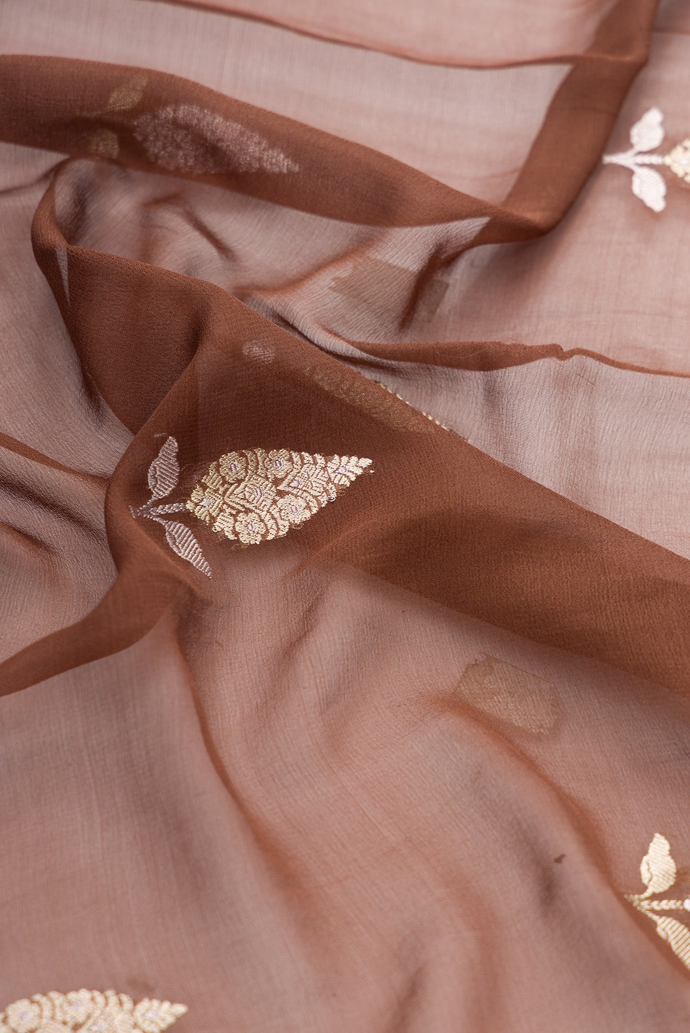 Close up of Brown Banarasi Georgette Saree with Zari Butta on the body and Fancy Border.  displaying folds