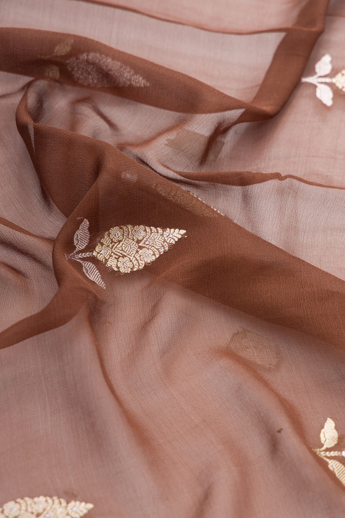 Close up of Brown Banarasi Georgette Saree with Zari Butta on the body and Fancy Border.  displaying folds