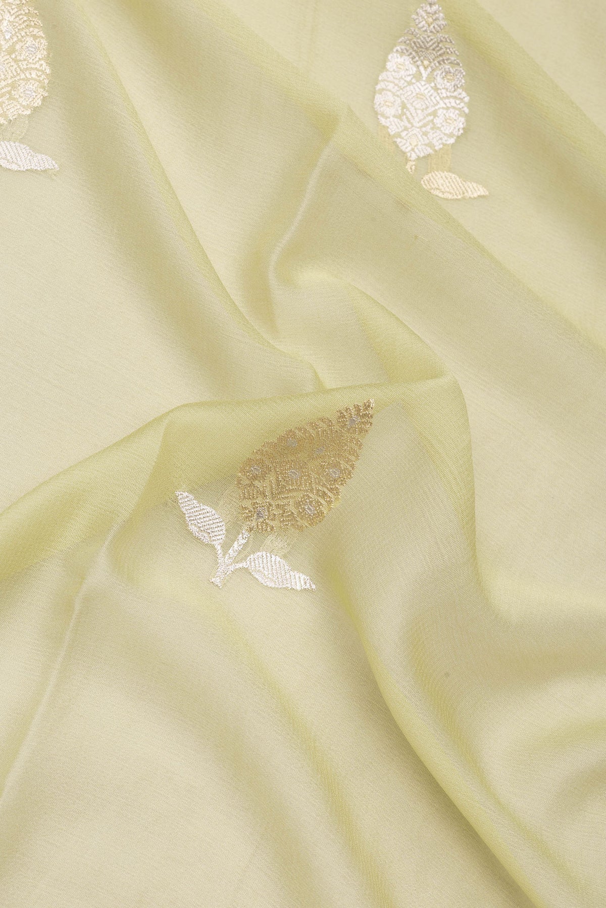 Close up of Pista Green Dual Tone Banarasi Georgette Saree with Zari Butta on the body and Fancy Border.  displaying folds