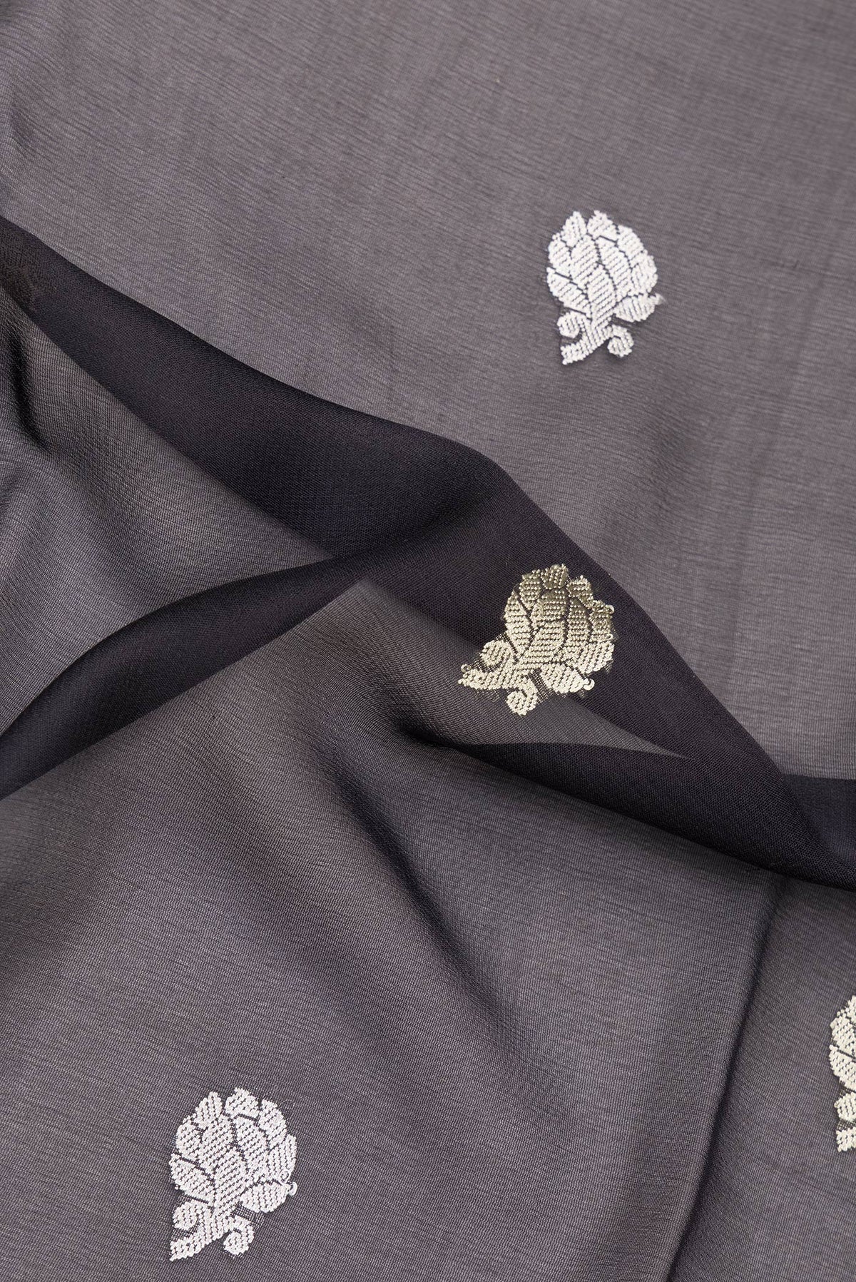 Close up of Black Banarasi Georgette Saree with Zari Butta on the body and Zari Border.  displaying folds