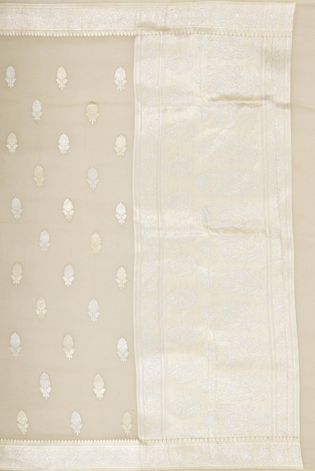 Close up image of the pallu of Beige Banarasi Georgette Saree with Zari Butta on the body and Zari Border. 