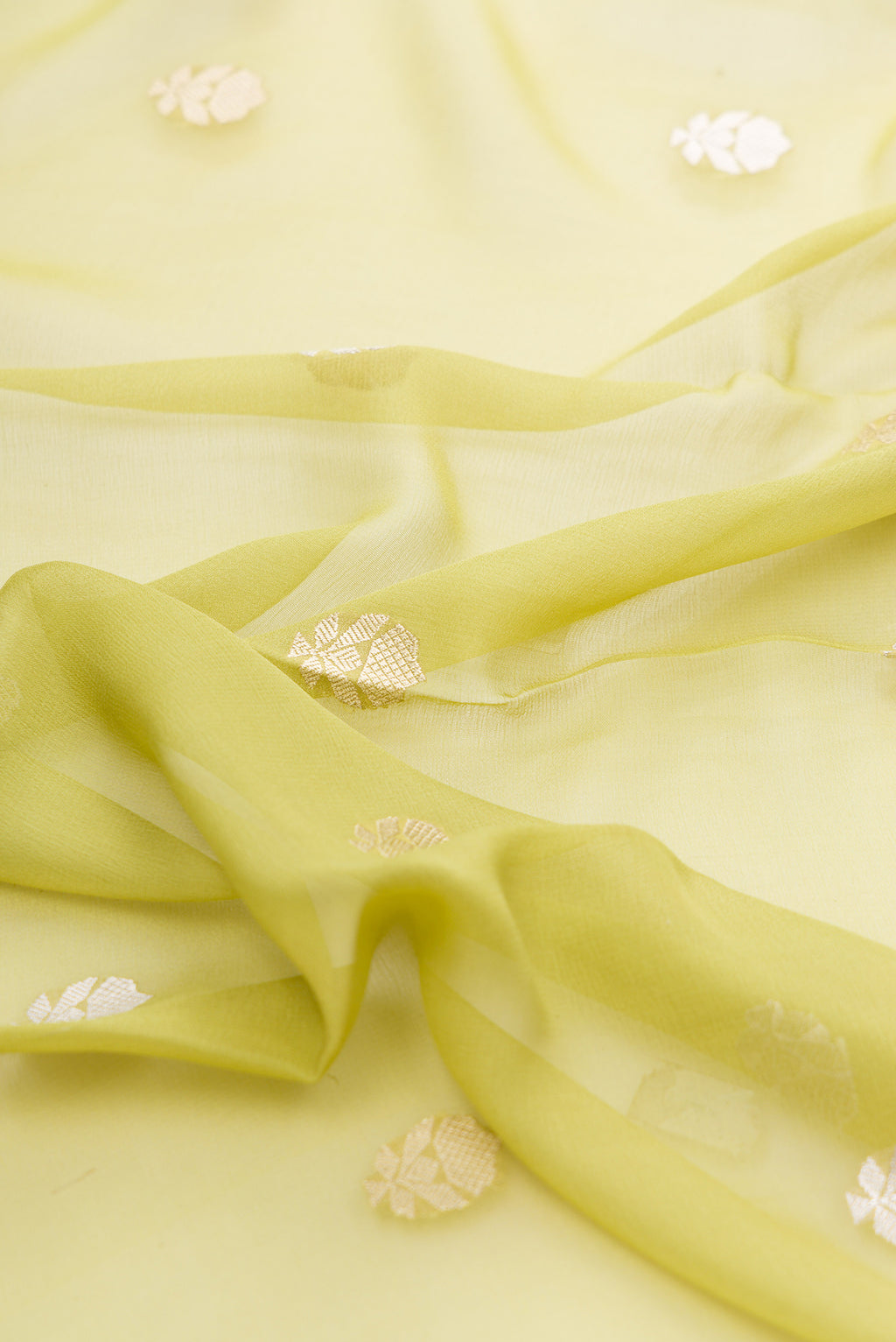Close up of Pista Green Banarasi Georgette Saree with Zari Butta on the body and Fancy Border.  displaying folds