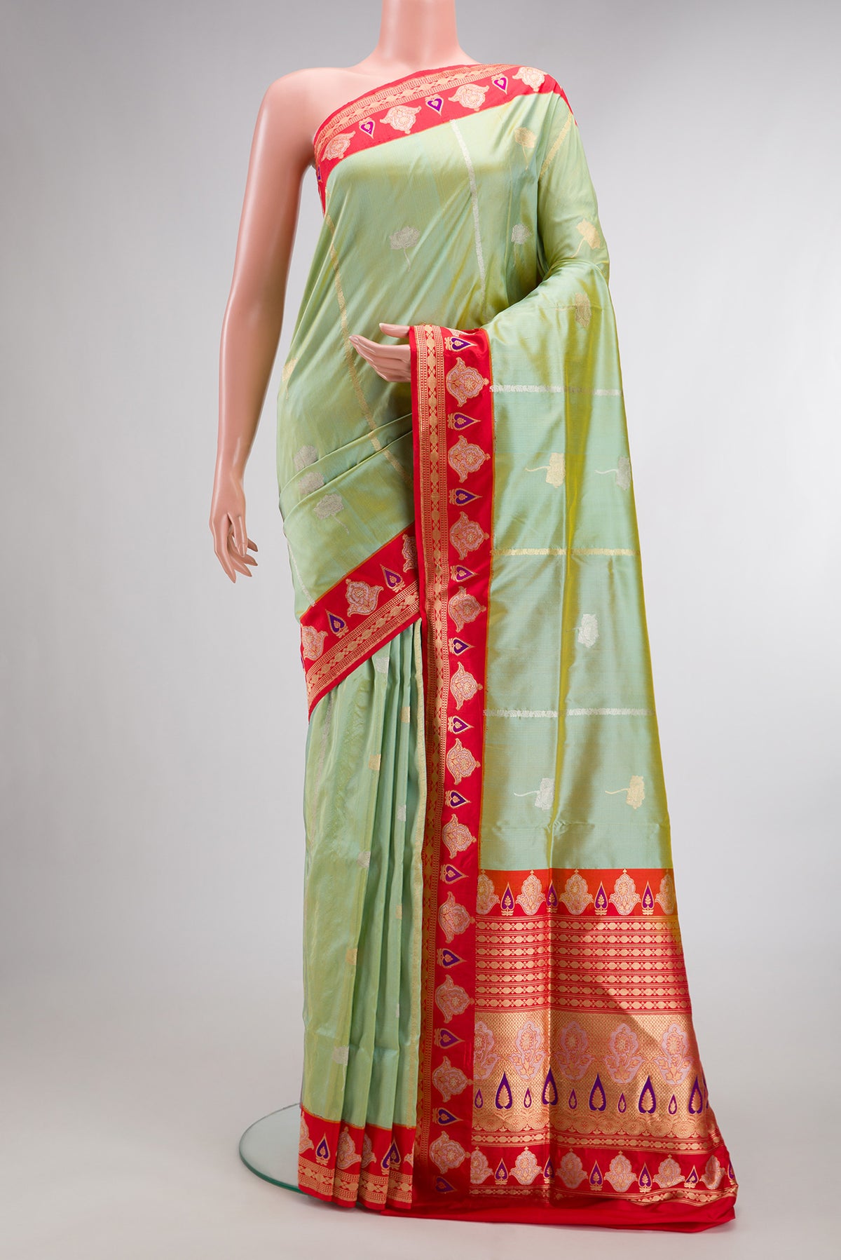 Pure Silk Pista Green Banarasi Saree with Zari Butta on the body and Fancy Border.  displayed on a mannequin