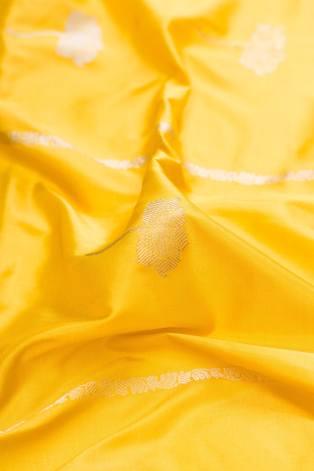 Close up of Pure Silk Yellow Banarasi Saree with Zari Butta on the body and Fancy Border.  displaying folds