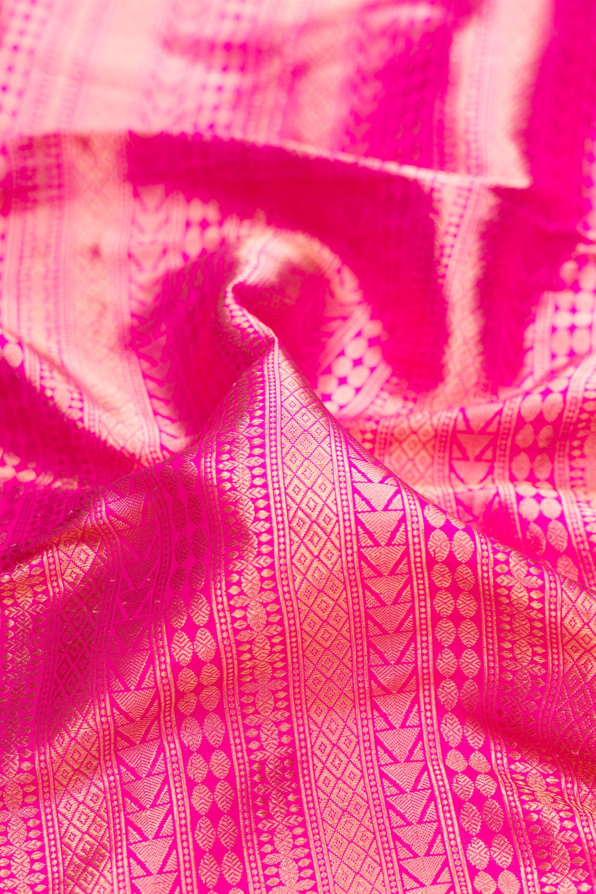 Close up of Pure Silk Dark Pink Banarasi Saree with Zari Brocade on the body and Fancy Border.  displaying folds
