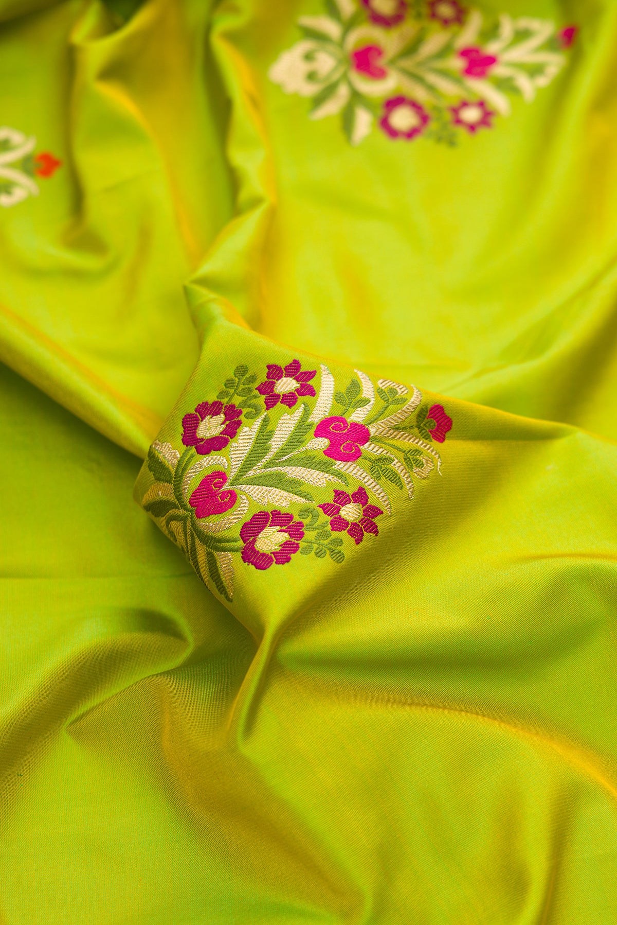 Close up of Pure Silk Parrot Green Dual Tone Banarasi Saree with Zari And Thread Butta on the body and Zari Border.  displaying folds