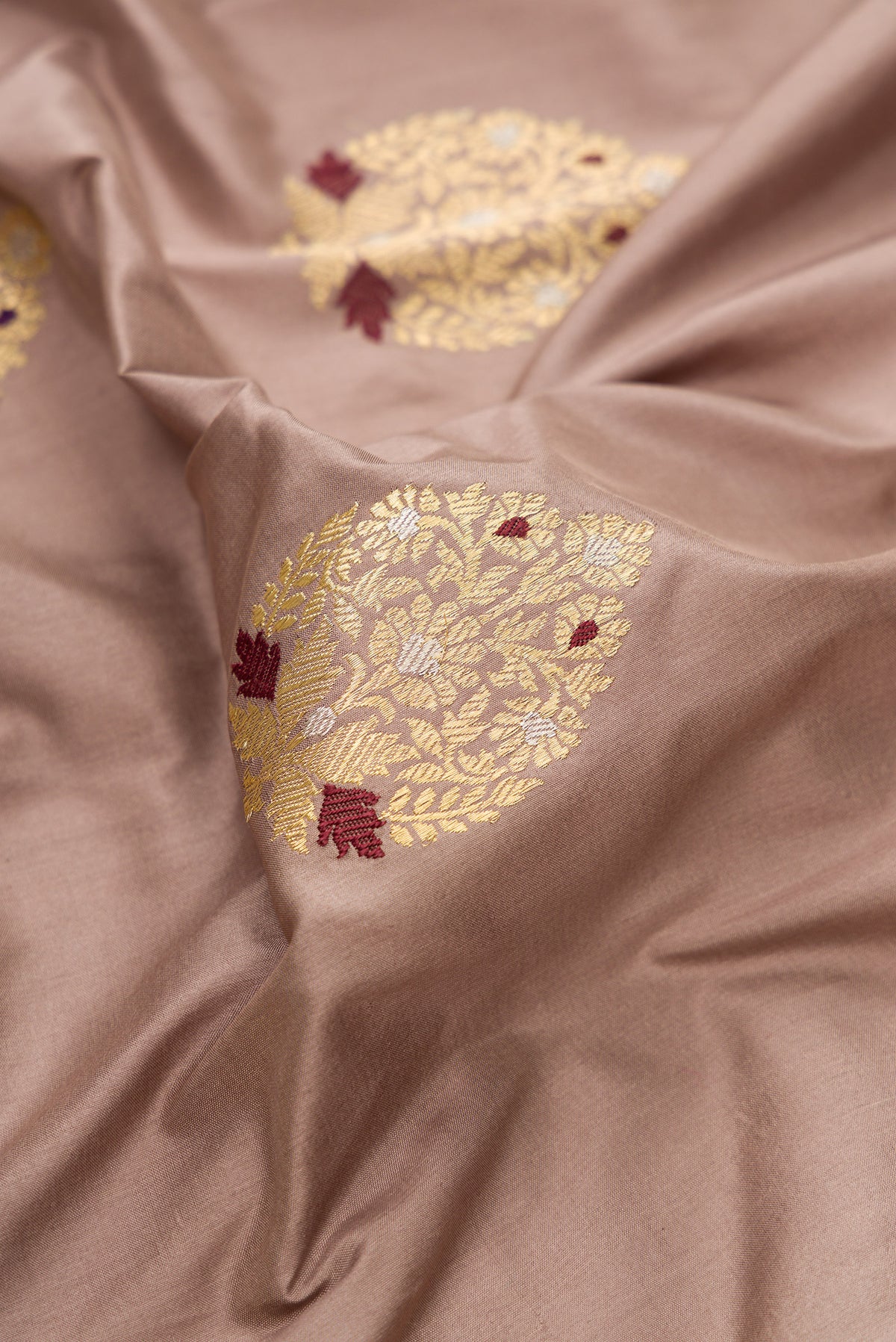 Close up of Pure Silk Brown Banarasi Saree with Zari And Thread Butta on the body and Zari Border.  displaying folds