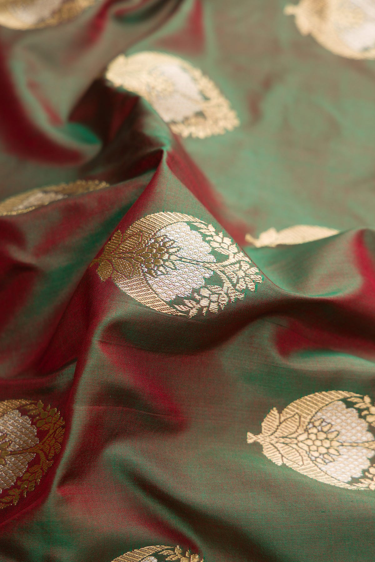 Close up of Pure Silk Mehandi Green Dual Tone Banarasi Saree with Zari And Thread Butta on the body and Fancy Border.  displaying folds