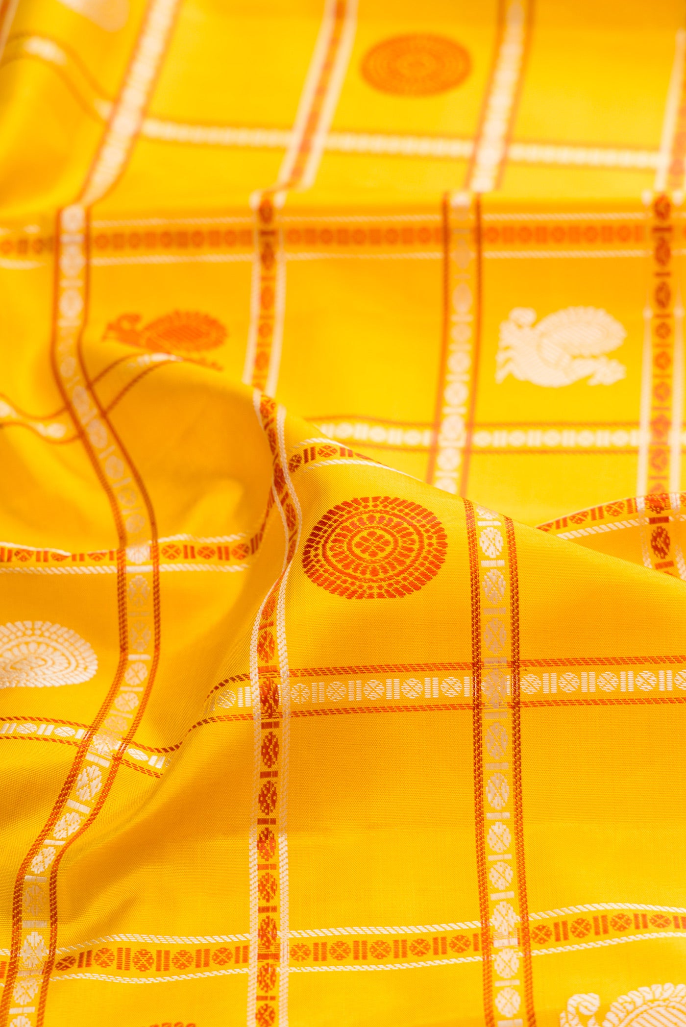 Close up of Yellow Kanchipuram Silk Saree with Checked design on the body and Thread Border.  displaying folds