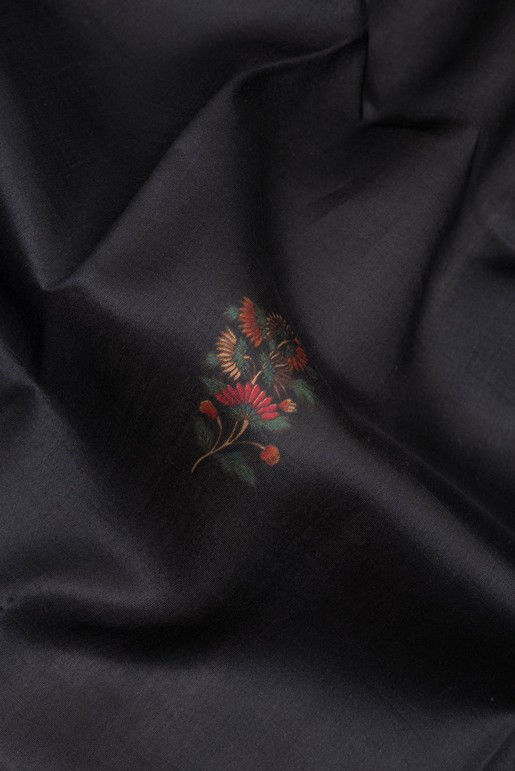Close up of Pure Silk Black Printed Saree with Printed design on the body and Fancy Border.  displaying folds
