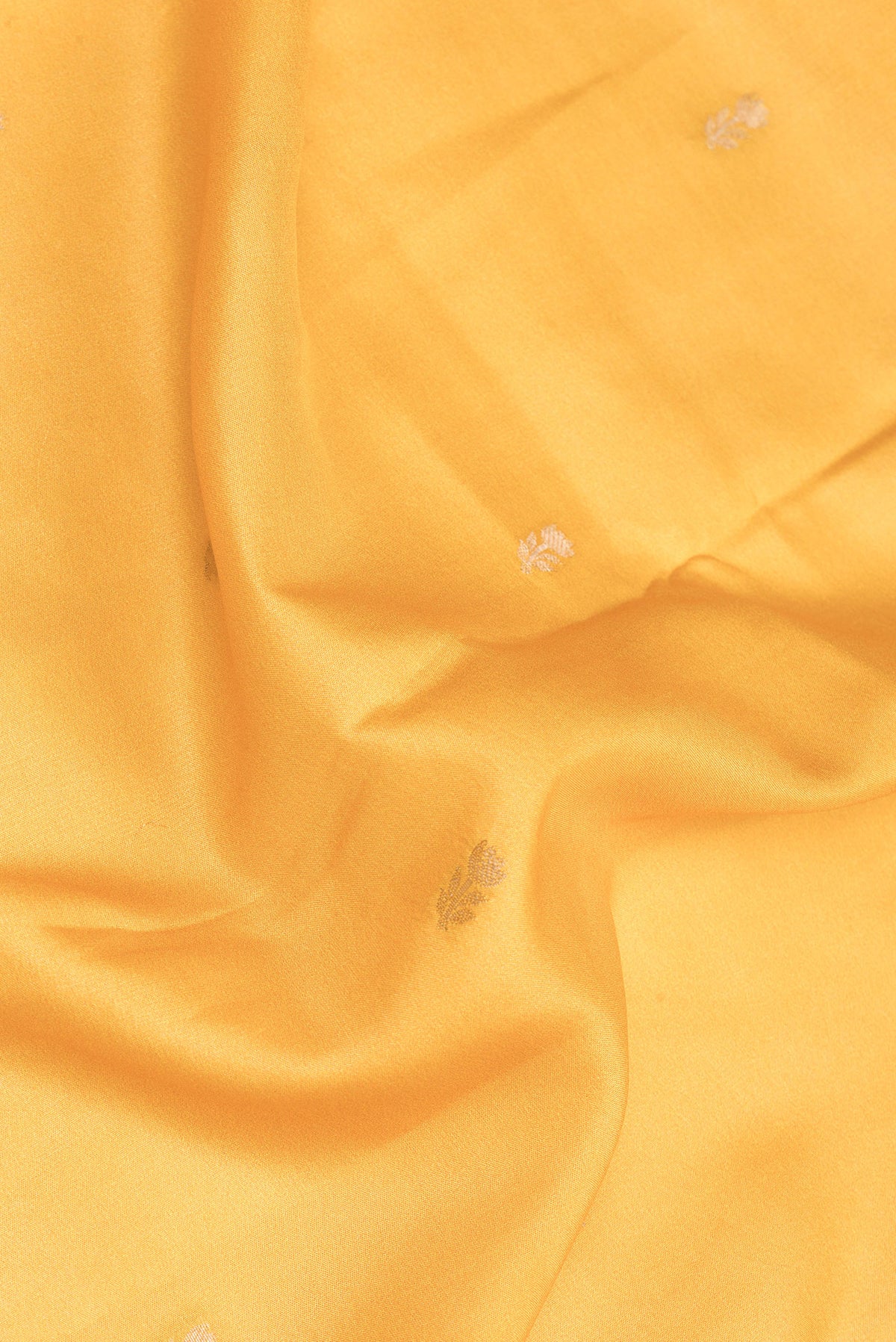 Close up of Mustard Dual Tone Crepe Saree with Zari Butta on the body and Fancy Border.  displaying folds