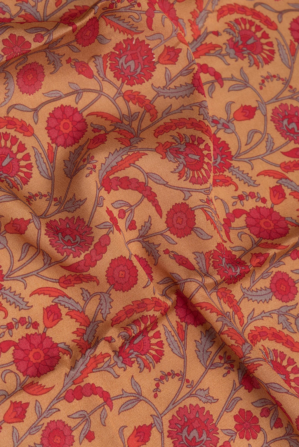 Close up of Brown Crepe Saree with Printed design on the body and Zari Border.  displaying folds