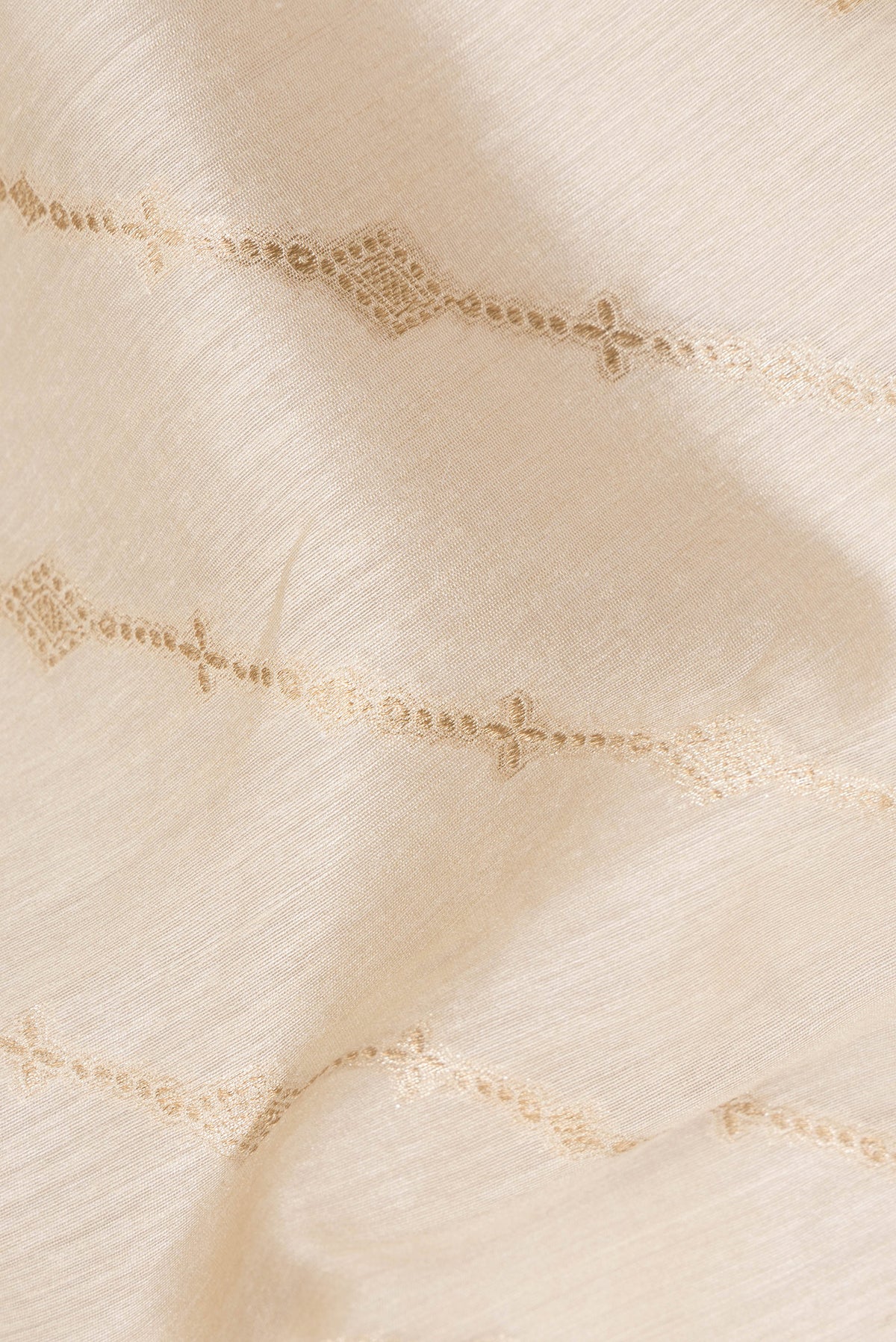 Close up of Cream Tussar Saree with Zari Butta on the body and Printed Border.  displaying folds
