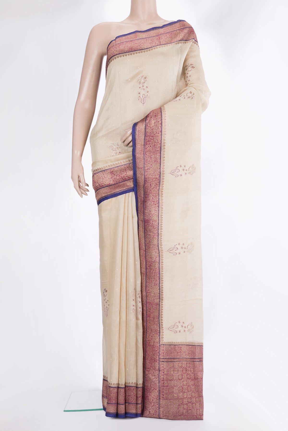 Cream Tussar Saree with Embroidered on the body and Zari Border.  displayed on a mannequin