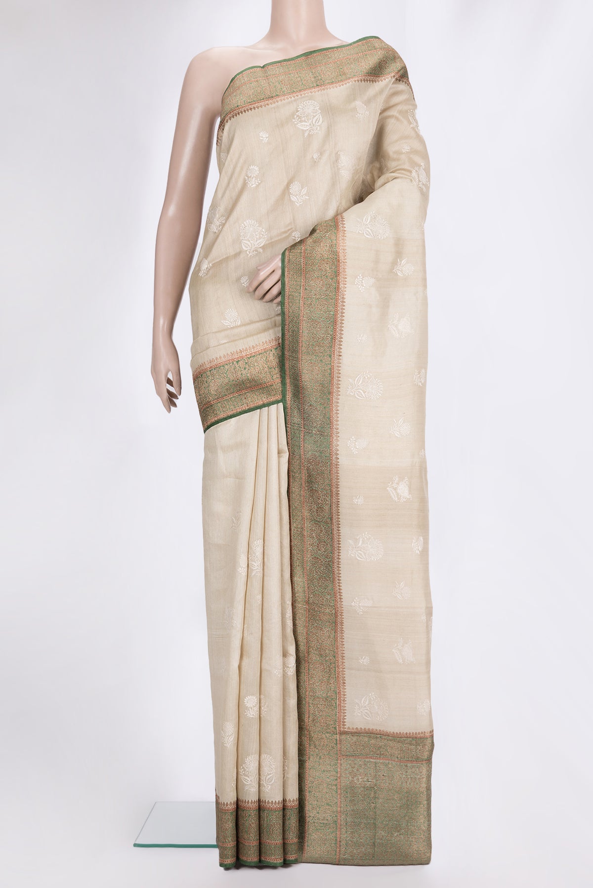 Beige Tussar Saree with Embroidered on the body and Zari Border.  displayed on a mannequin