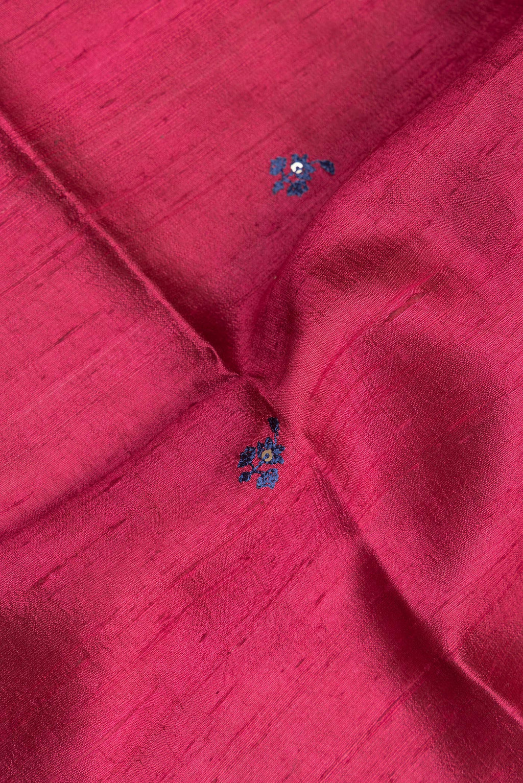Close up of Pure Silk Dark Pink Tussar Saree with Embroidery on the body and Zari Border.  displaying folds