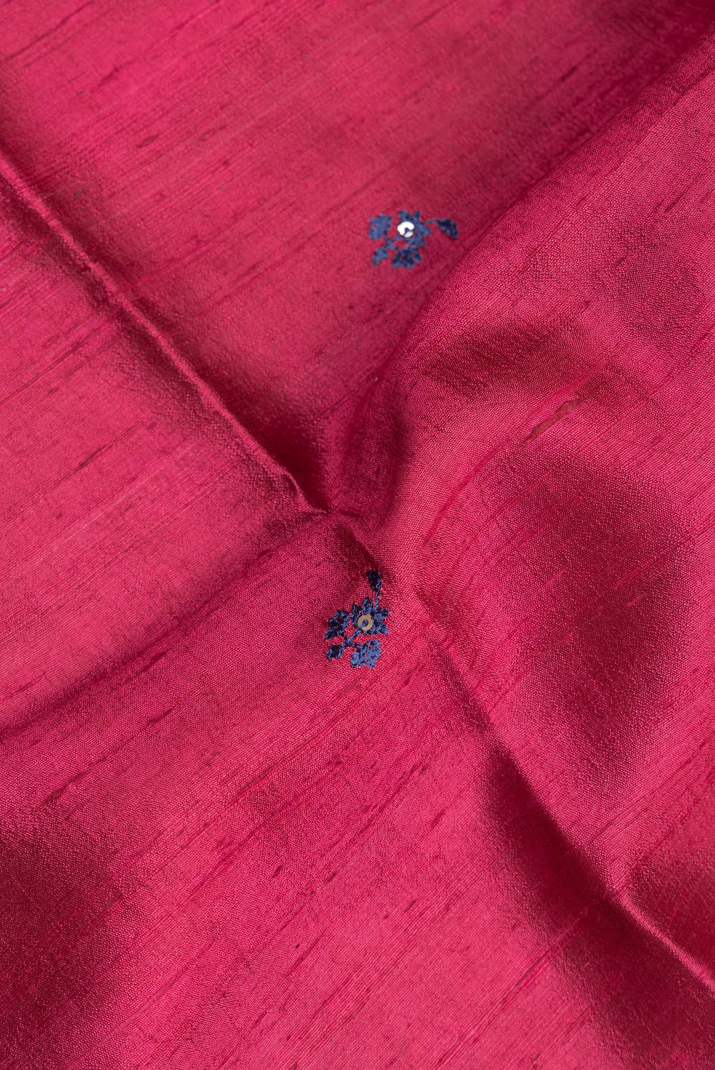 Close up of Pure Silk Dark Pink Tussar Saree with Embroidery on the body and Zari Border.  displaying folds