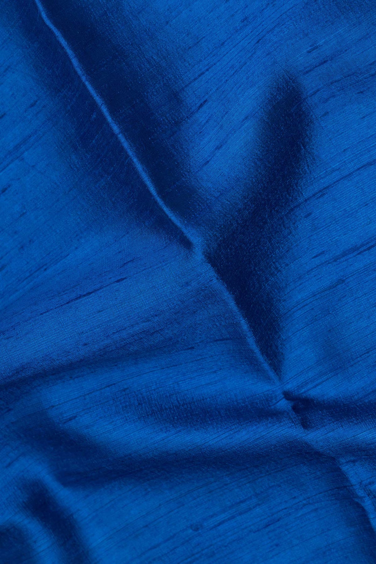 Close up of Pure Silk Royal Blue Tussar Saree with Plain Body and Zari Border.  displaying folds