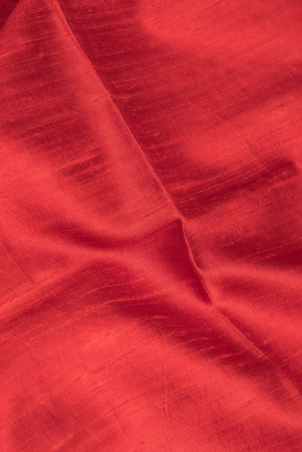 Close up of Pure Silk Red Tussar Saree with Plain Body and Zari Border.  displaying folds