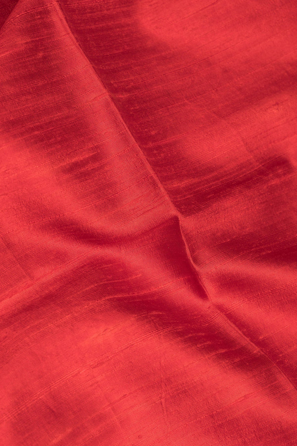 Close up of Pure Silk Red Tussar Saree with Plain Body and Zari Border.  displaying folds