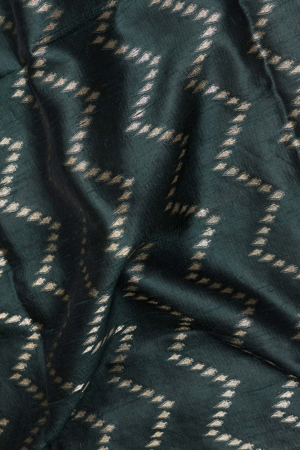 Close up of Pure Silk Bottle Green Tussar Saree with Zig Zag design on the body and Zari Border.  displaying folds
