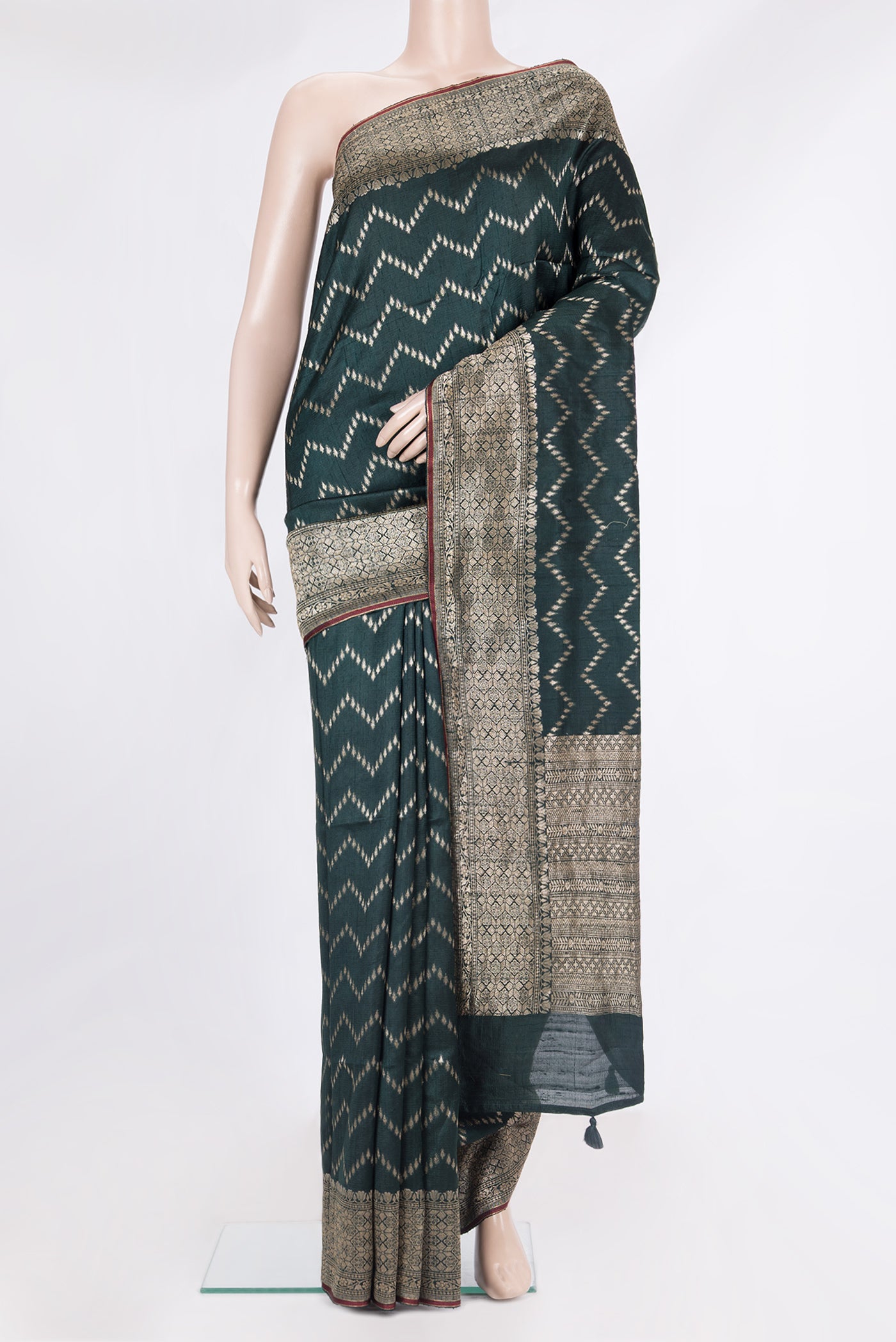 Pure Silk Bottle Green Tussar Saree with Zig Zag design on the body and Zari Border.  displayed on a mannequin