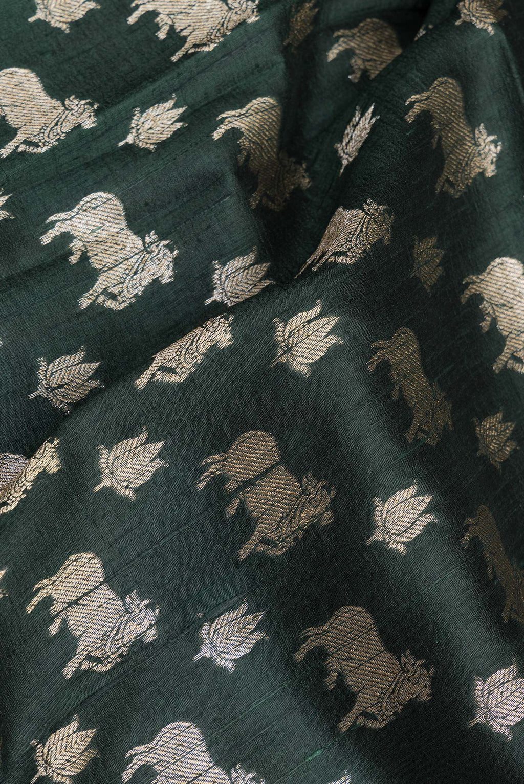 Close up of Pure Silk Bottle Green Tussar Saree with Zari Butta on the body and Zari Border.  displaying folds