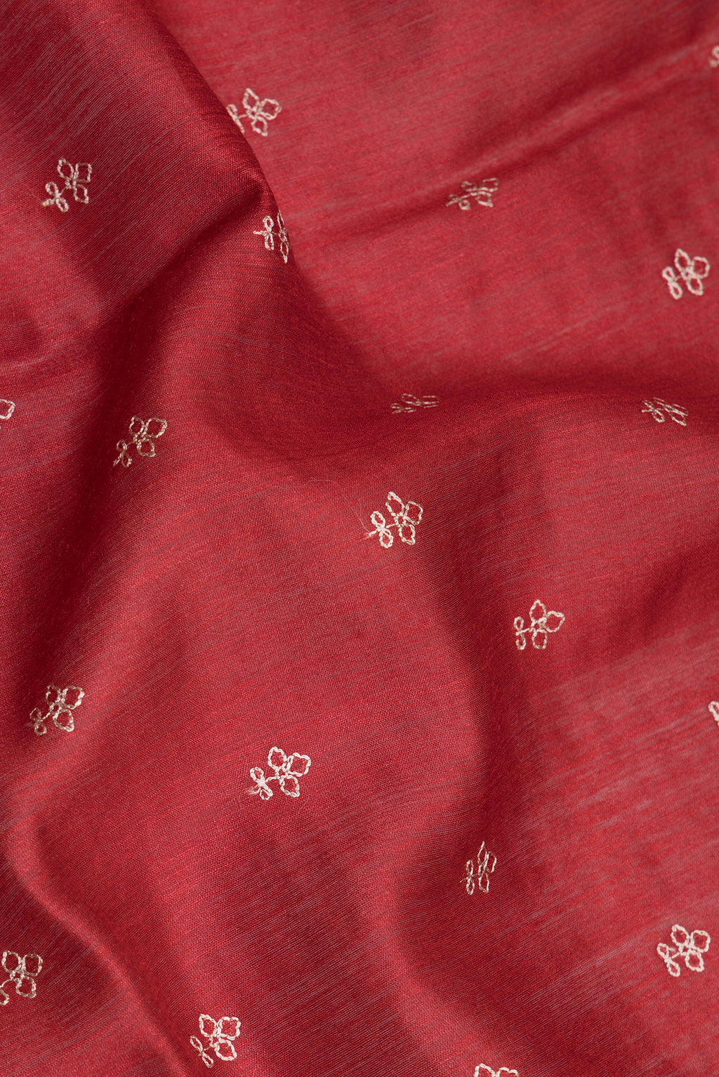 Close up of Red Tussar Silk Saree with Embroidery on the body and Fancy Border.  displaying folds