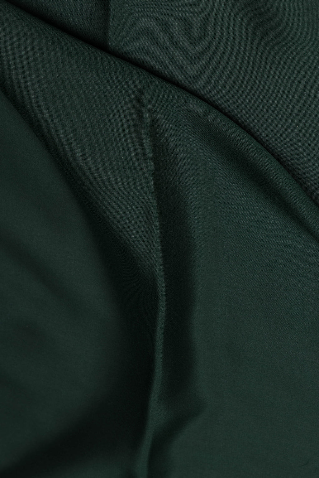 Close up of Bottle Green Mysore Crepe Saree with Plain Body and Zari Border.  displaying folds