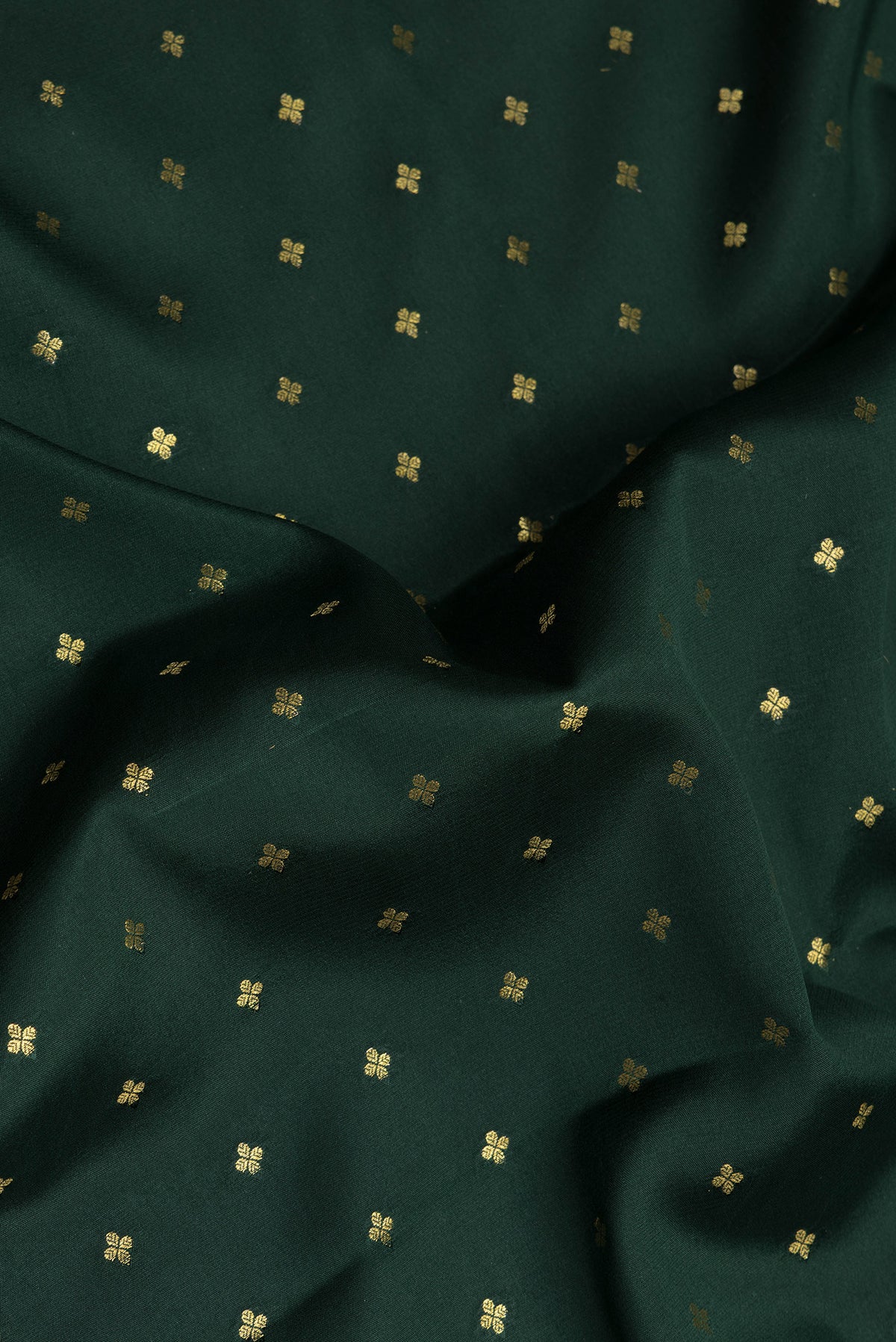 Close up of Bottle Green Mysore Chiffon Saree with Zari Butta on the body and Zari Border.  displaying folds