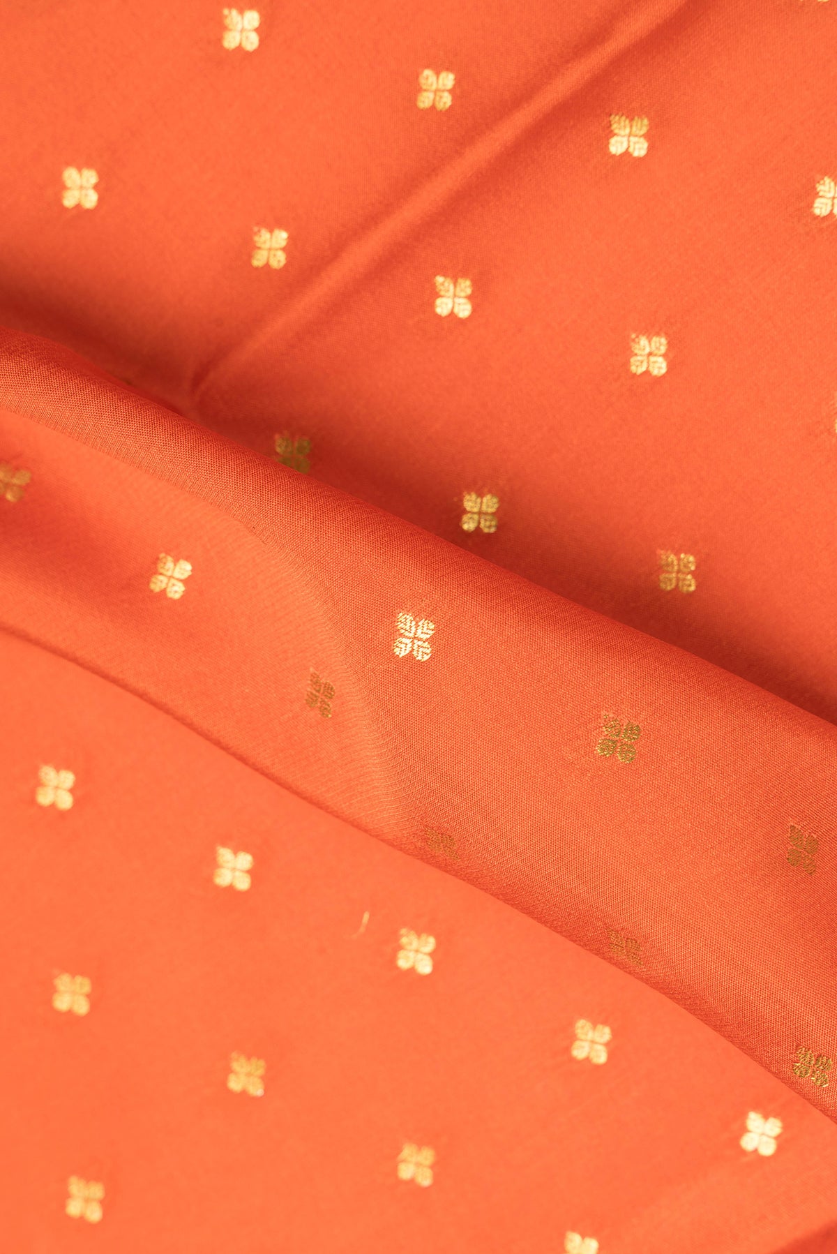 Close up of Pure Silk Orange Mysore Silk Saree with Zari Butta on the body and Zari Border.  displaying folds