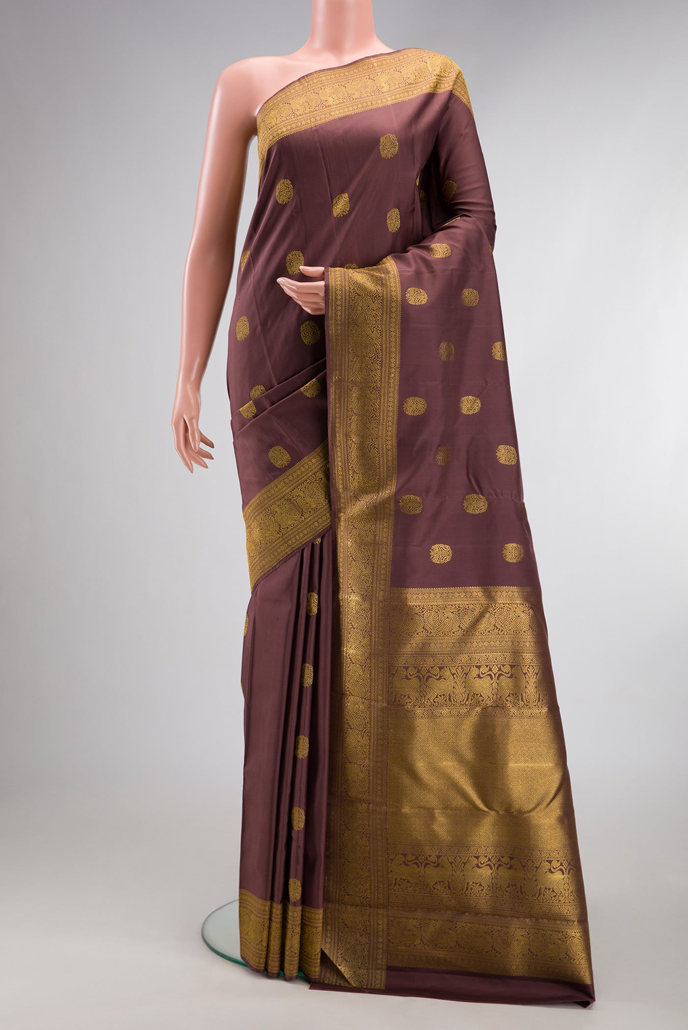Pure Silk Pure Zari Brown Kanjivaram Saree with Zari Butta on the body and Zari Border.  displayed on a mannequin